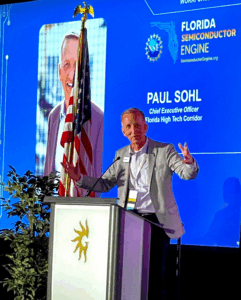 Paul Sohl at a podium with a screen depicting his name and image in the background.