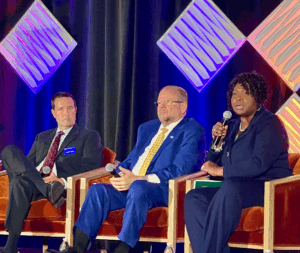 David Arnold, Alexander Cartwright and Sylvia Wilson Thomas sitting next to each other on a stage. Thomas is speaking into the microphone.