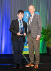 Jackie Chang accepts the Dan Webster award from Paul Sohl.